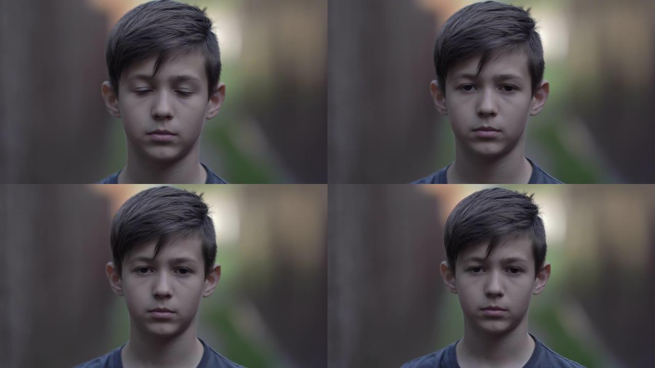 难民悲伤的男孩同情地看着相机，脸上的疼痛，移动的相机