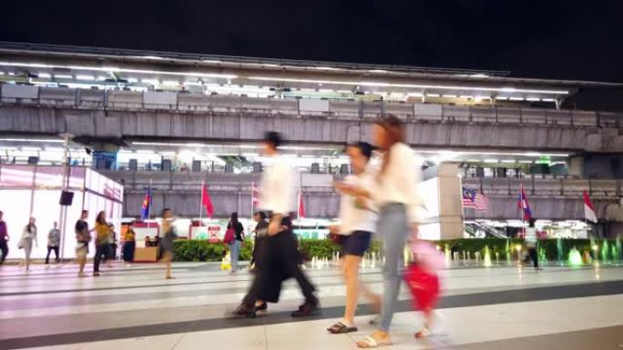 夜间步行人群在BTS天空火车站附近的中央人行道上行走