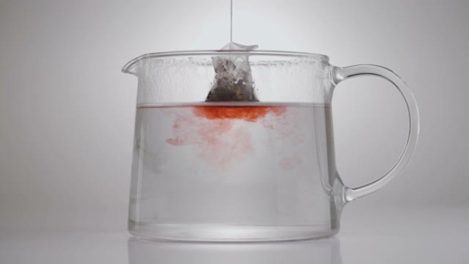 茶包浸泡在玻璃壶中的特写演示视频。水果茶制作。