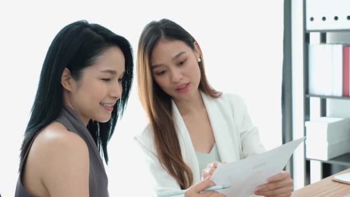 两位美丽的亚洲女性在办公室开会讨论或集思广益创业项目。赋权女性团队合作的概念。