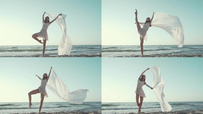 年轻美丽的芭蕾舞演员在海边跳芭蕾舞，巨大的丝绸织物随风飘扬。大自然的温柔，轻盈，艺术和才华的概念