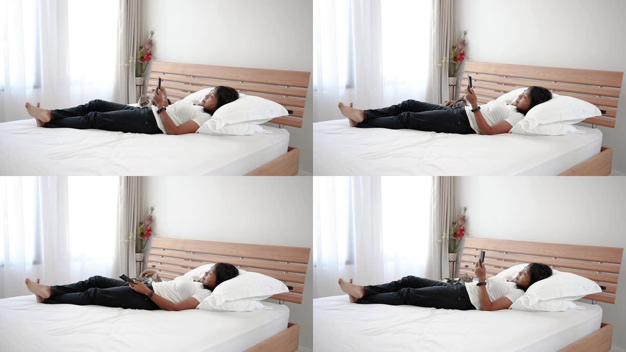 亚洲女性使用智能手机在现代卧室玩虎斑猫。