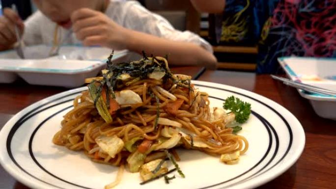 亚洲女孩在餐厅吃日式食物