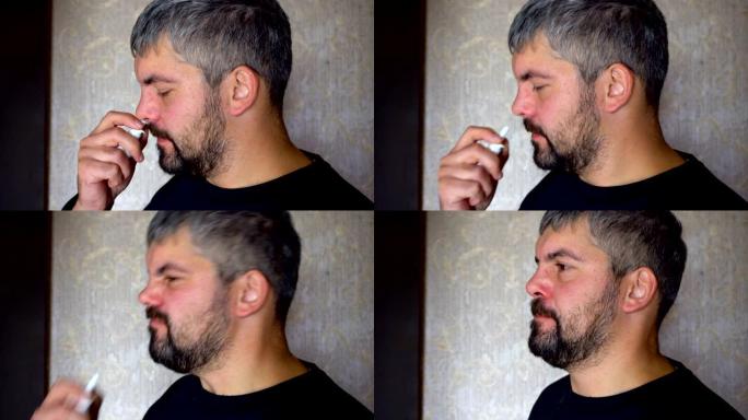 一个留着胡子的不健康的人在鼻子里吃药