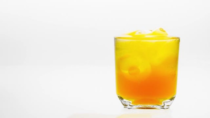 时间流逝，带有冰的橙汁在白色背景上融化。