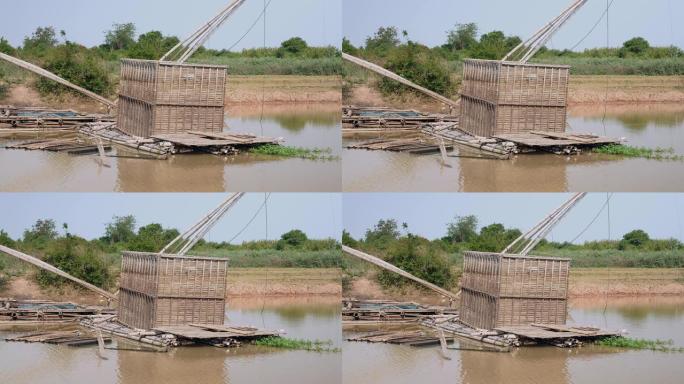 退潮时从河中冒出来的竹鱼箱; 中国渔网后面