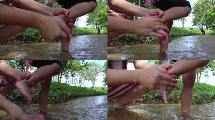 妈妈玩耍后在溪水中洗脚。