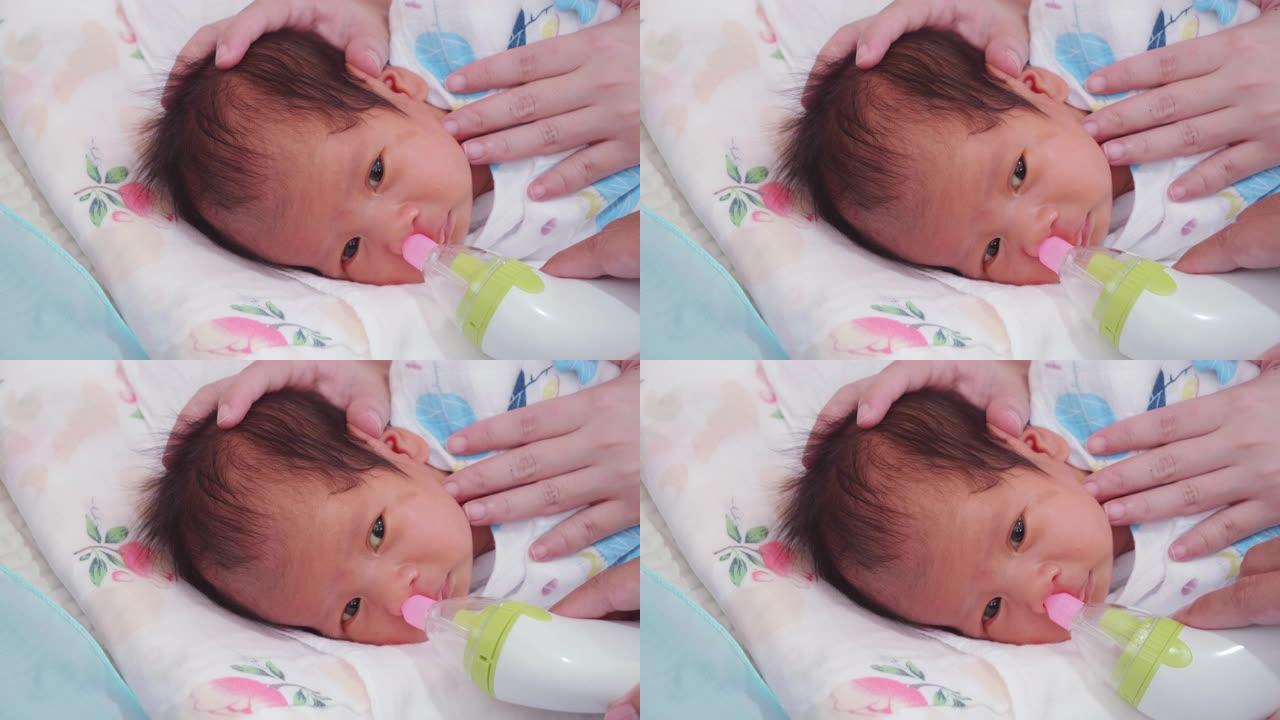 新生儿; 用吸气器清洁婴儿的鼻子。