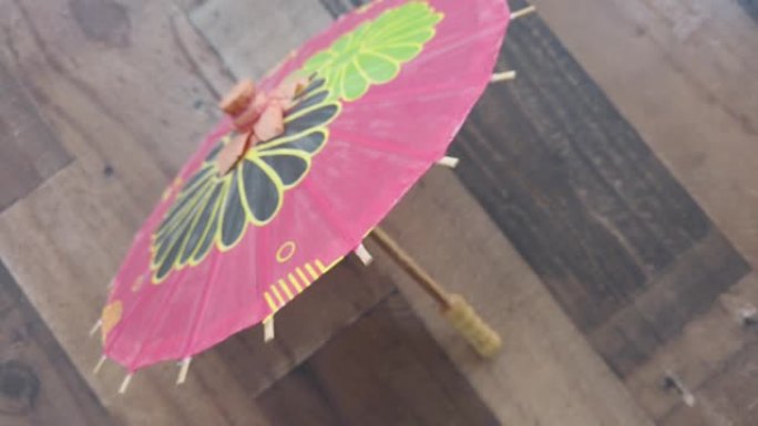 拉开棕色木质背景上的小红纸亚洲雨伞。