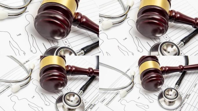 医学图表上的木制法官木槌和听诊器。医疗纠纷概念。