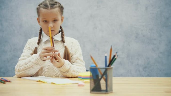 漂亮的小学生发现很难削她的棕色铅笔。