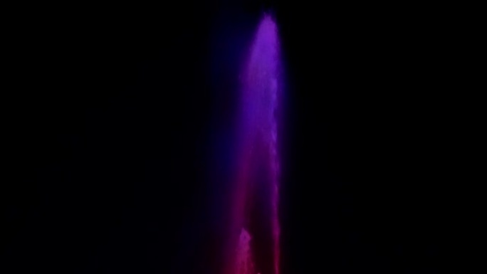 喷泉的水射流在夜空的背景下被光照亮