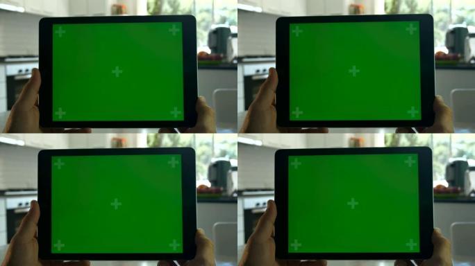 手握的平板电脑。绿屏色度键。特写。