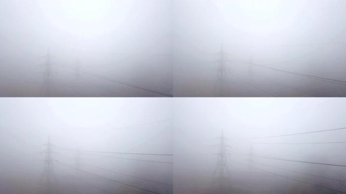 雾中的高压电源线。无人机飞行
