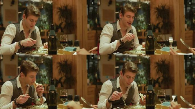 在舒适的餐厅吃晚餐，一个英俊的家伙在吃沙拉和聊天。肖像视图。