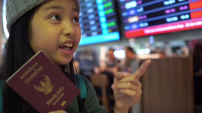亚洲小女孩在机场的旅程，检查航班时刻表