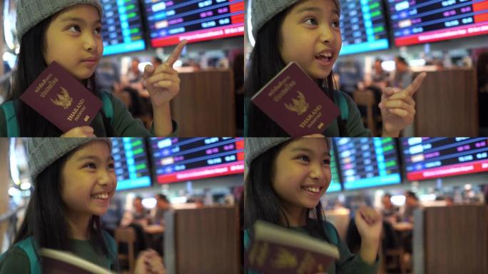 亚洲小女孩在机场的旅程，检查航班时刻表