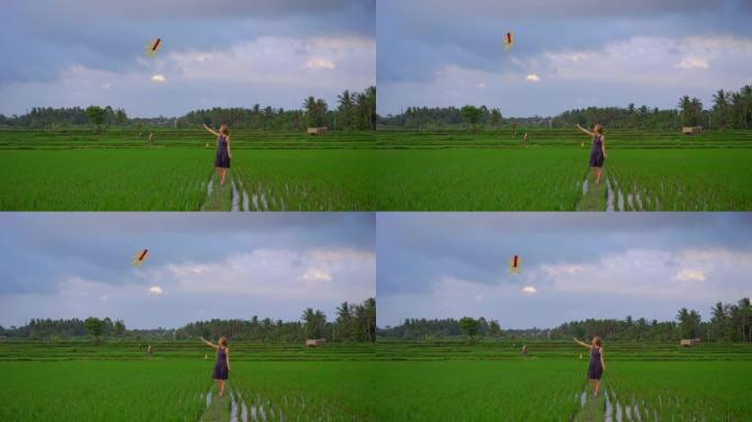 慢动作拍摄一名年轻女子的风筝穿过美丽的稻田