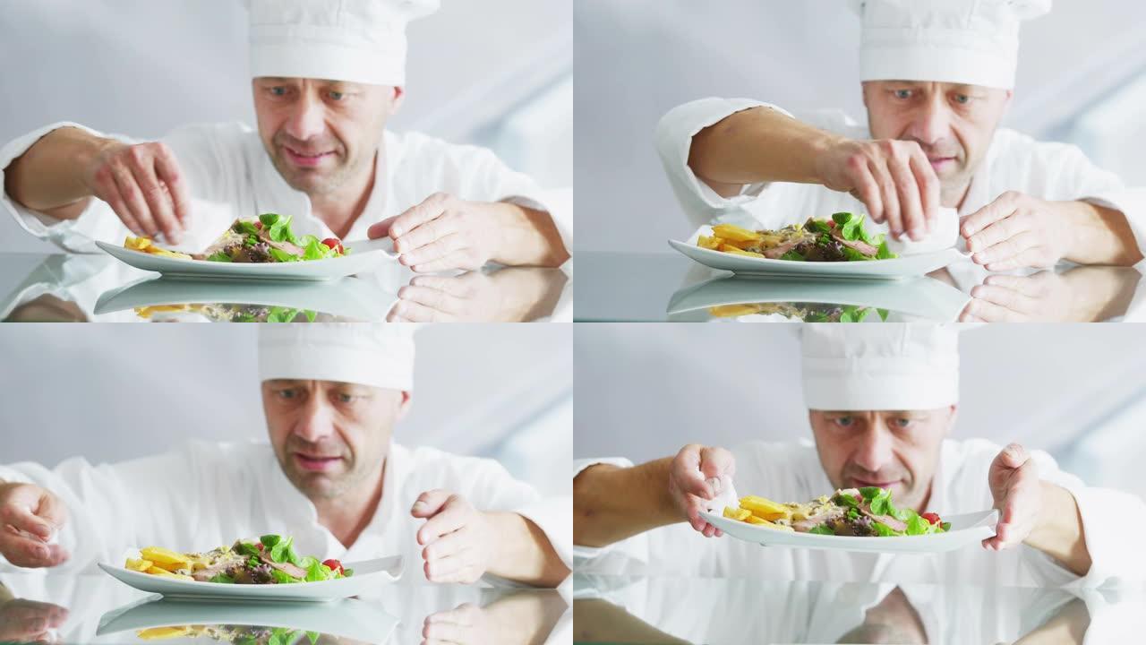 厨师专业人员用布和装饰餐点清洁盘子。用牛肉烹制沙拉。以RAW格式在黑魔法电影摄像机6k上拍摄的慢动作
