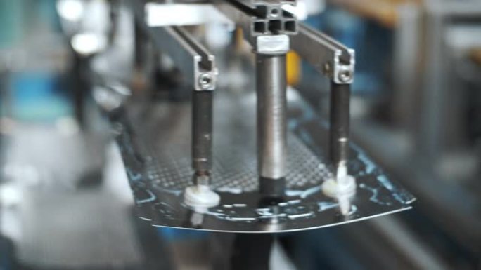 机器人机械手在工厂移动用于洗涤滚筒的穿孔金属板