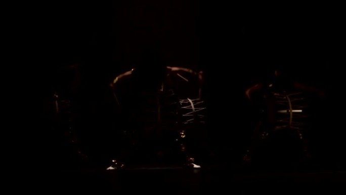 四位艺术家在黑暗背景下的舞台上，用带角和化妆鼓的假发鼓手Taiko。日本神话中的恶魔。没有声音。