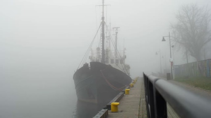 在大雾的早晨停泊在堤岸的渔船