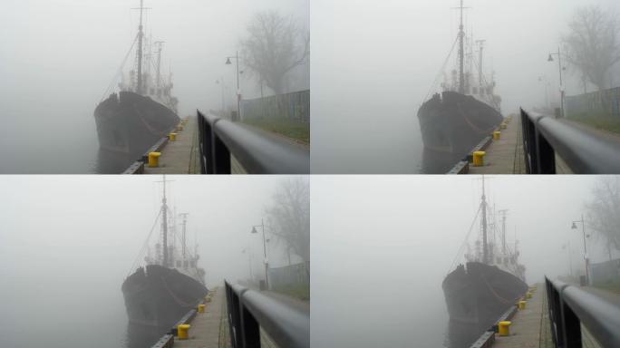 在大雾的早晨停泊在堤岸的渔船