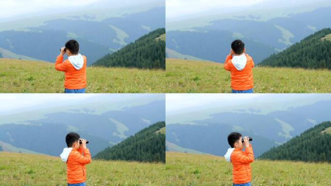 亚洲男孩在草原上用望远镜看风景