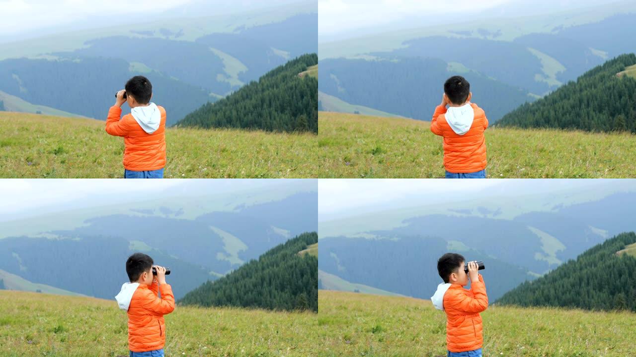 亚洲男孩在草原上用望远镜看风景