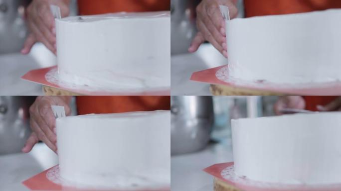 女人在海绵蛋糕上涂抹奶油。