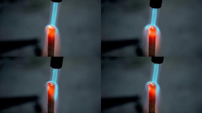 燃气燃烧器的火加热红热金属螺栓特写