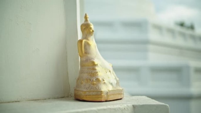 金佛被塑料覆盖，位于寺内。相机平移镜头