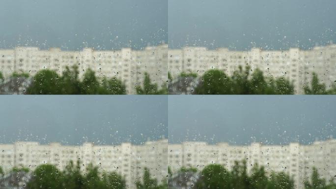 窗户玻璃上的水滴。城市的夏雨，蓝天，房屋和绿树的模糊轮廓。4k视频