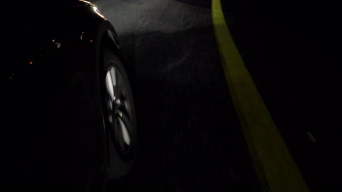 夜间行驶的黑色汽车上的轮辋和前轮胎