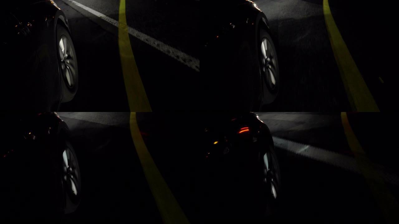 夜间行驶的黑色汽车上的轮辋和前轮胎