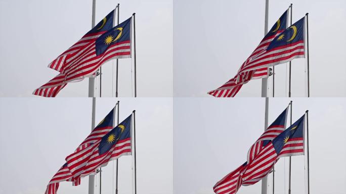 三面马来西亚国旗在多云的天空中飘扬