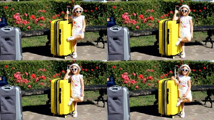 带着黄色大手提箱的女婴游客。等待旅行的孩子。