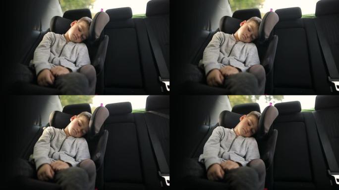 周末有趣的活动后，疲惫的小孩坐在汽车安全座椅上睡觉