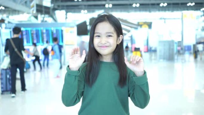 亚洲小女孩在机场的旅程，等待她的航班，面部表情，招手
