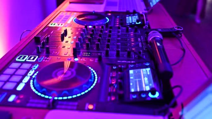 迪斯科舞厅的DJ在遥控器后面工作。舞池和轻音乐。