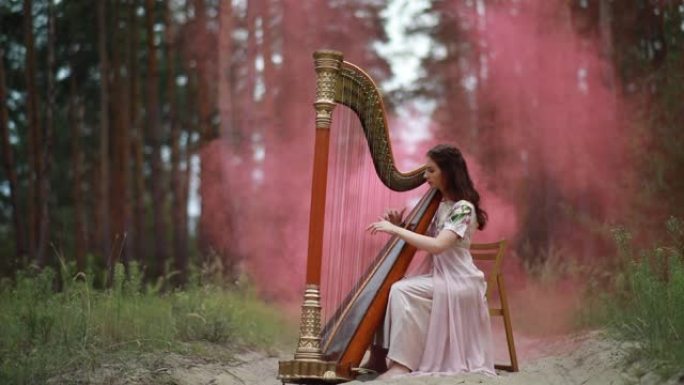 女竖琴手坐在林道上弹奏竖琴。