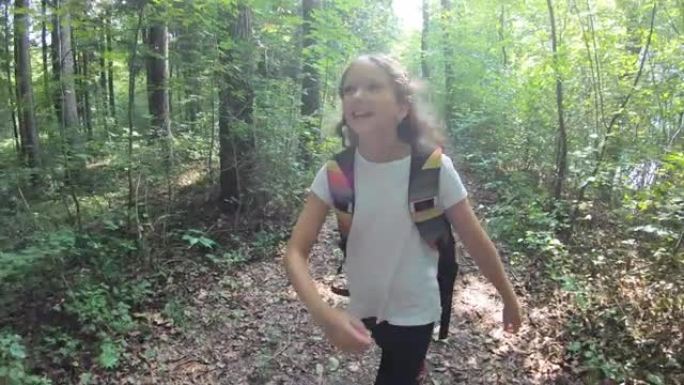 快乐的少女背着背包跳进森林