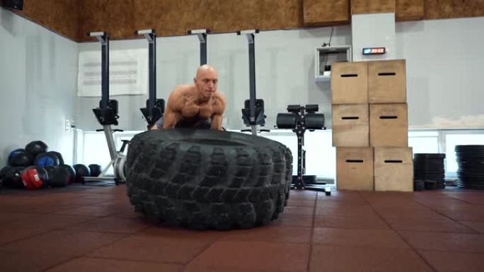 健身肌肉发达的人在健身房锻炼大橡胶轮胎