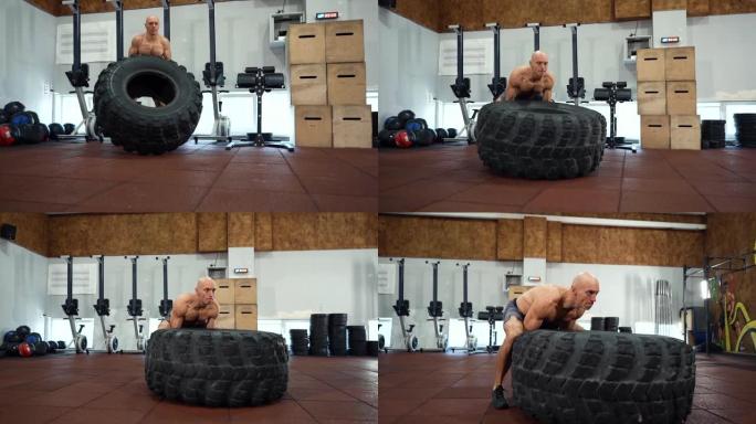 健身肌肉发达的人在健身房锻炼大橡胶轮胎