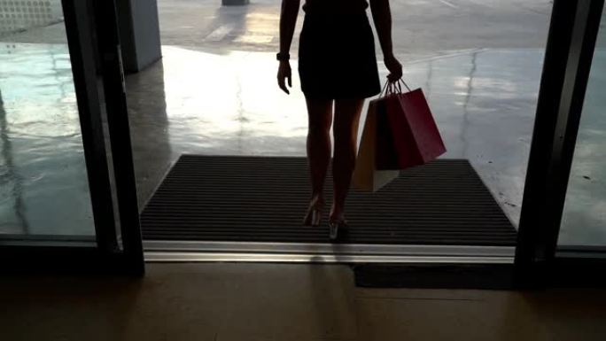 用购物袋走路的女性腿的慢动作