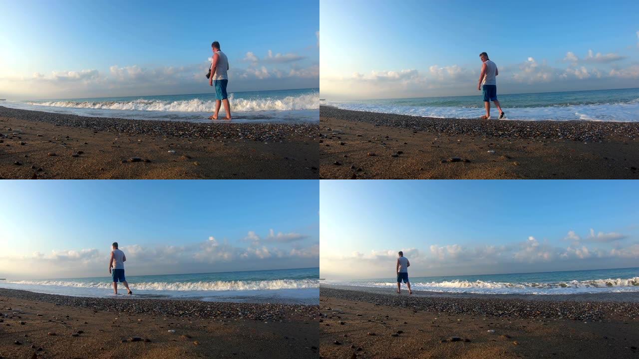 摄影师在黎明时走在海滩上。