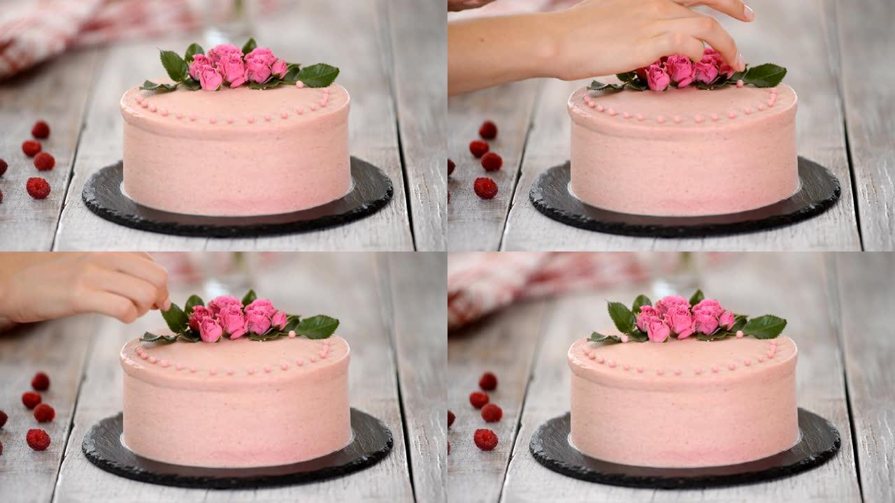 用粉红巧克力豆装饰蛋糕的过程。用饼干和奶油馅，浆果烹饪多层蛋糕。