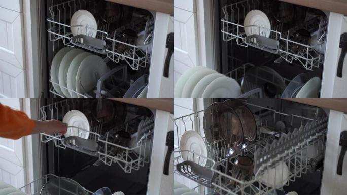 一名妇女打开洗碗机并取出干净的盘子