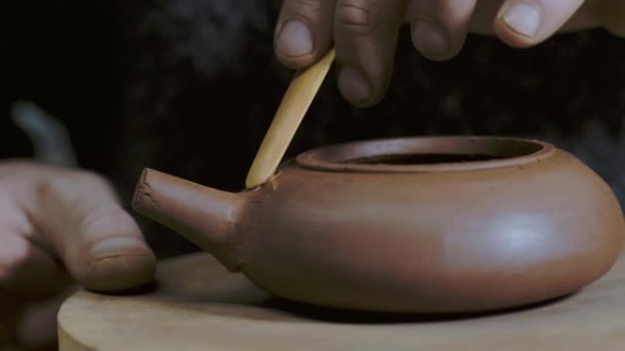 工匠将茶壶壶嘴连接到宜兴粘土的底部。中国茶道茶壶。4k视频。59.94 fps