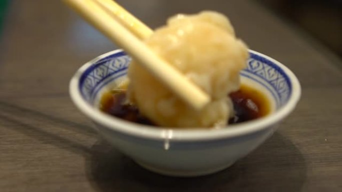慢动作的人用棍子吃大虾亚洲餐厅的饺子